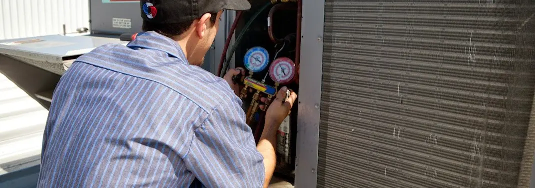 HVAC technician servicing a condenser unit in Oakbrook