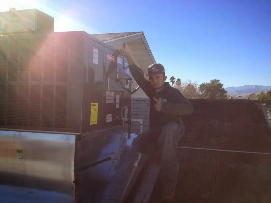 HVAC technician performing HVAC Inspection on a rooftop unit in Oakbrook